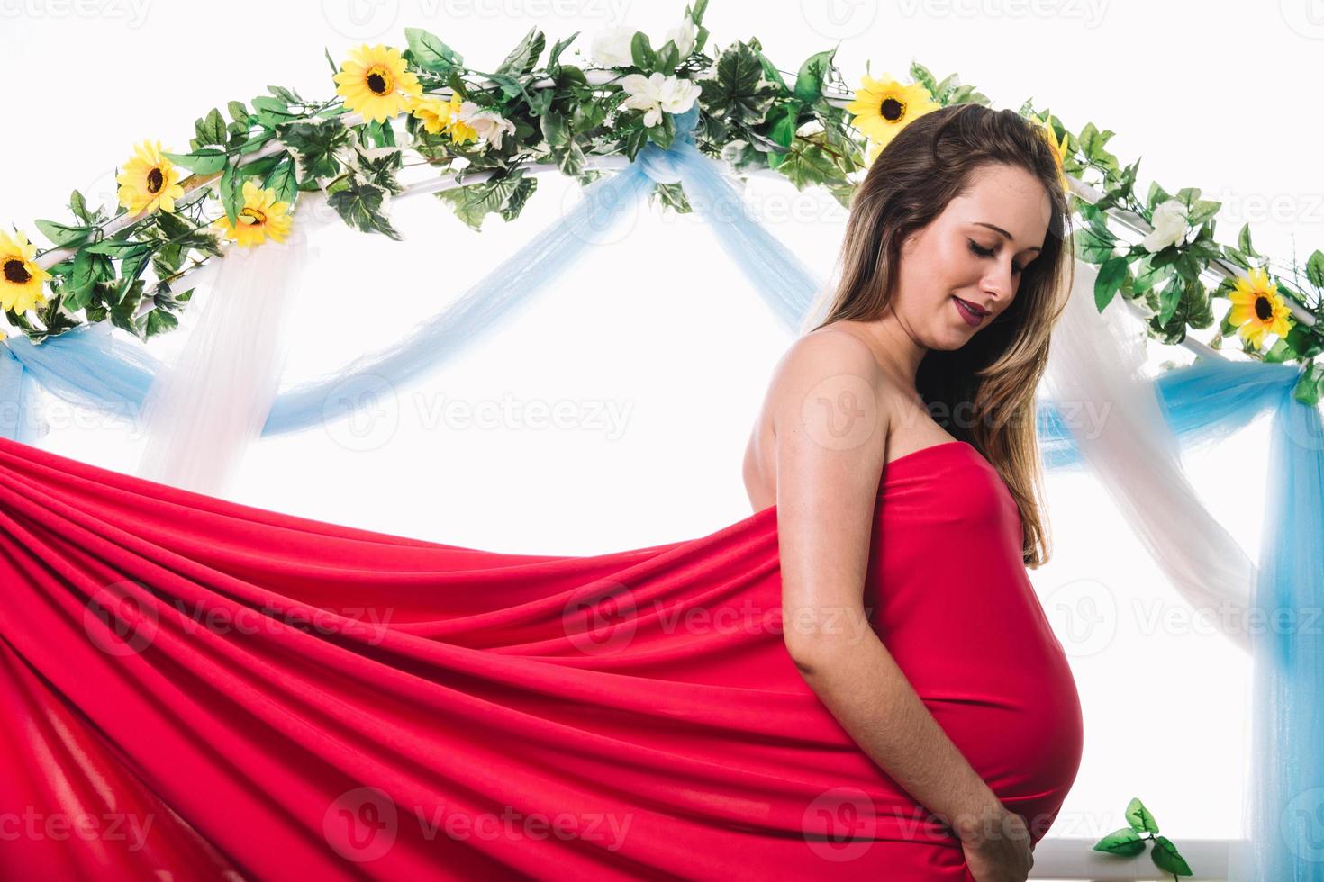 Young beautiful pregnant woman is posing. Looking her belly photo