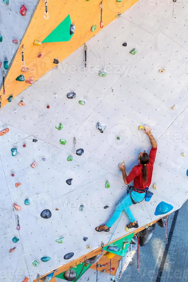 un hombre está escalando un muro de escalada foto