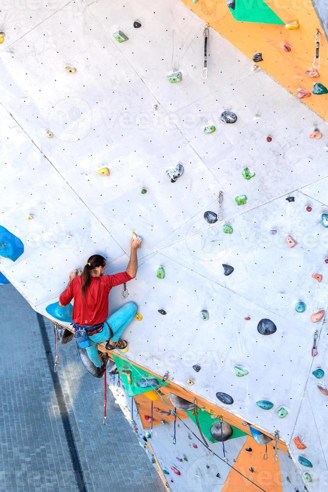 A man is climbing a climbing wall photo