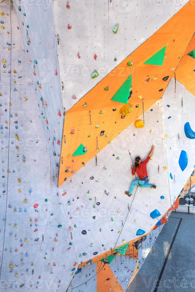 A man is climbing a climbing wall photo