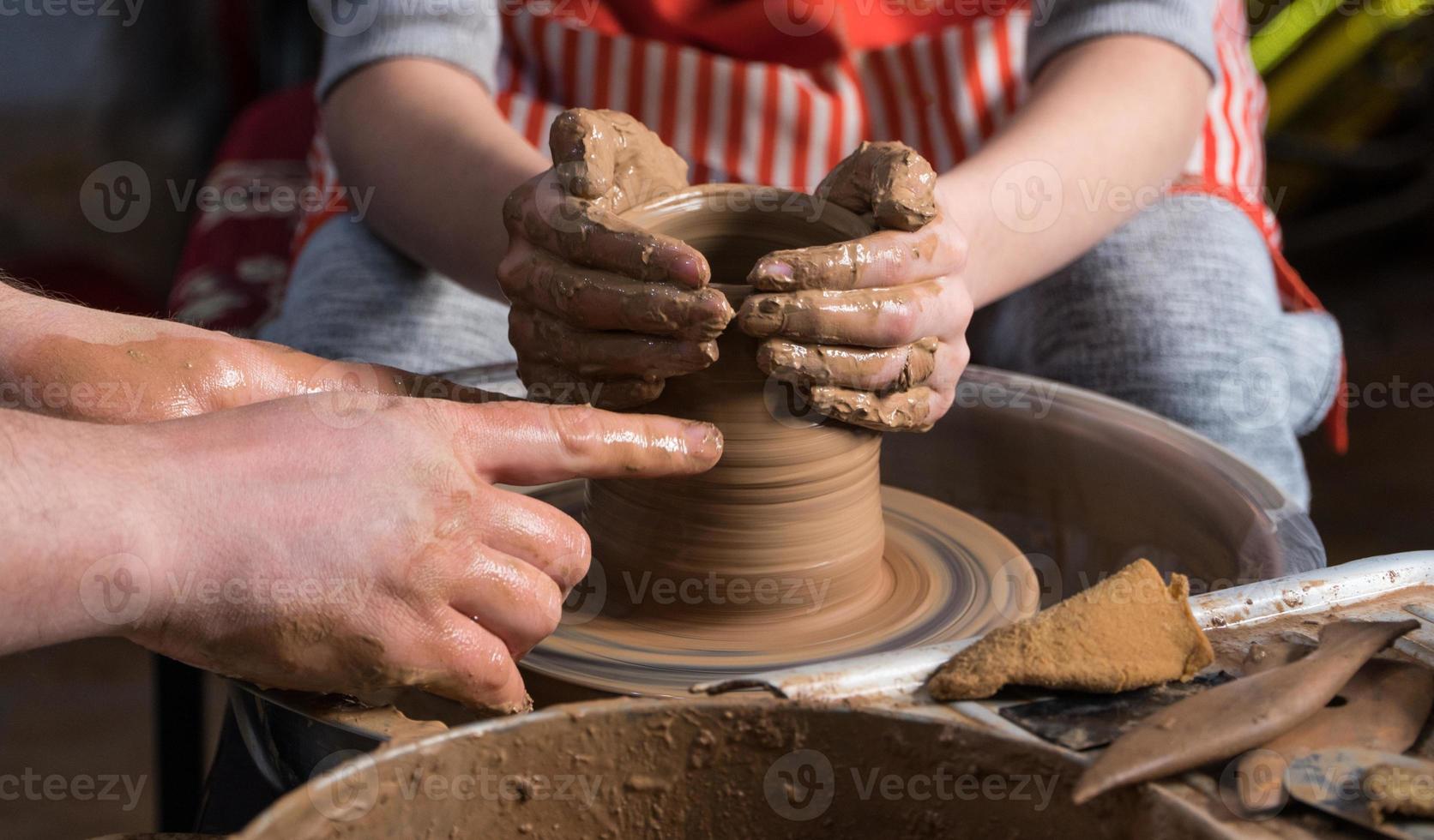 Teaching pottery to children. The teacher gives a master class in modeling photo