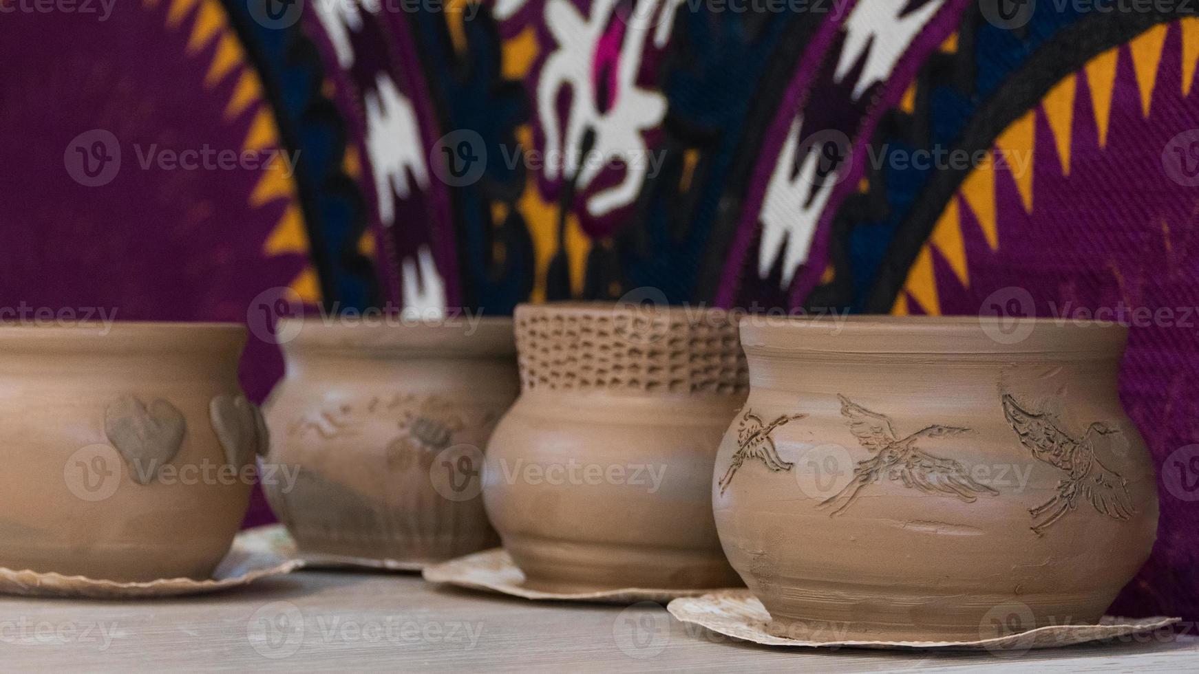 freshly made clay pots on a decorative background. children's crafts photo