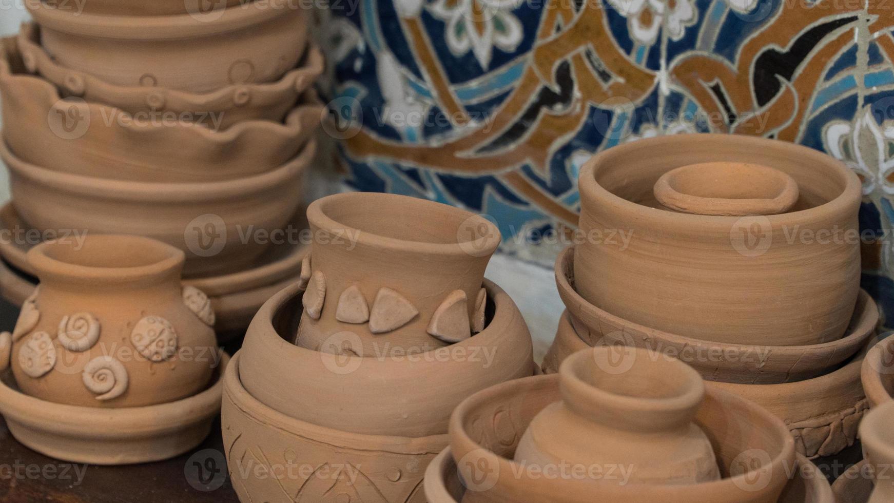 freshly made clay pots on a decorative mosaic background. children's crafts photo