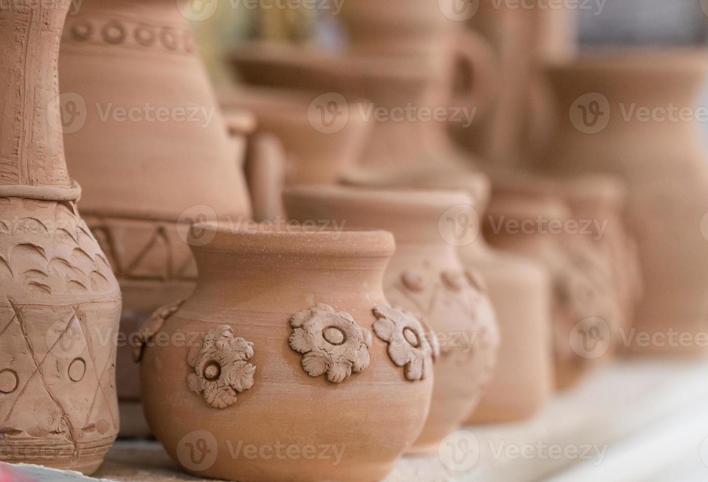 clay pots on the shelf, blurred background. children's crafts photo