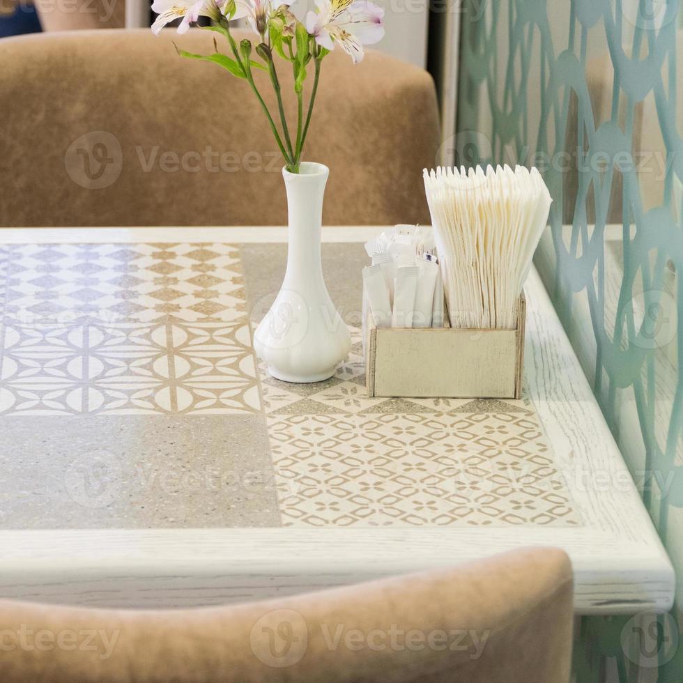 paper napkins and flowers on the table of a fashionable restaurant, close-up photo