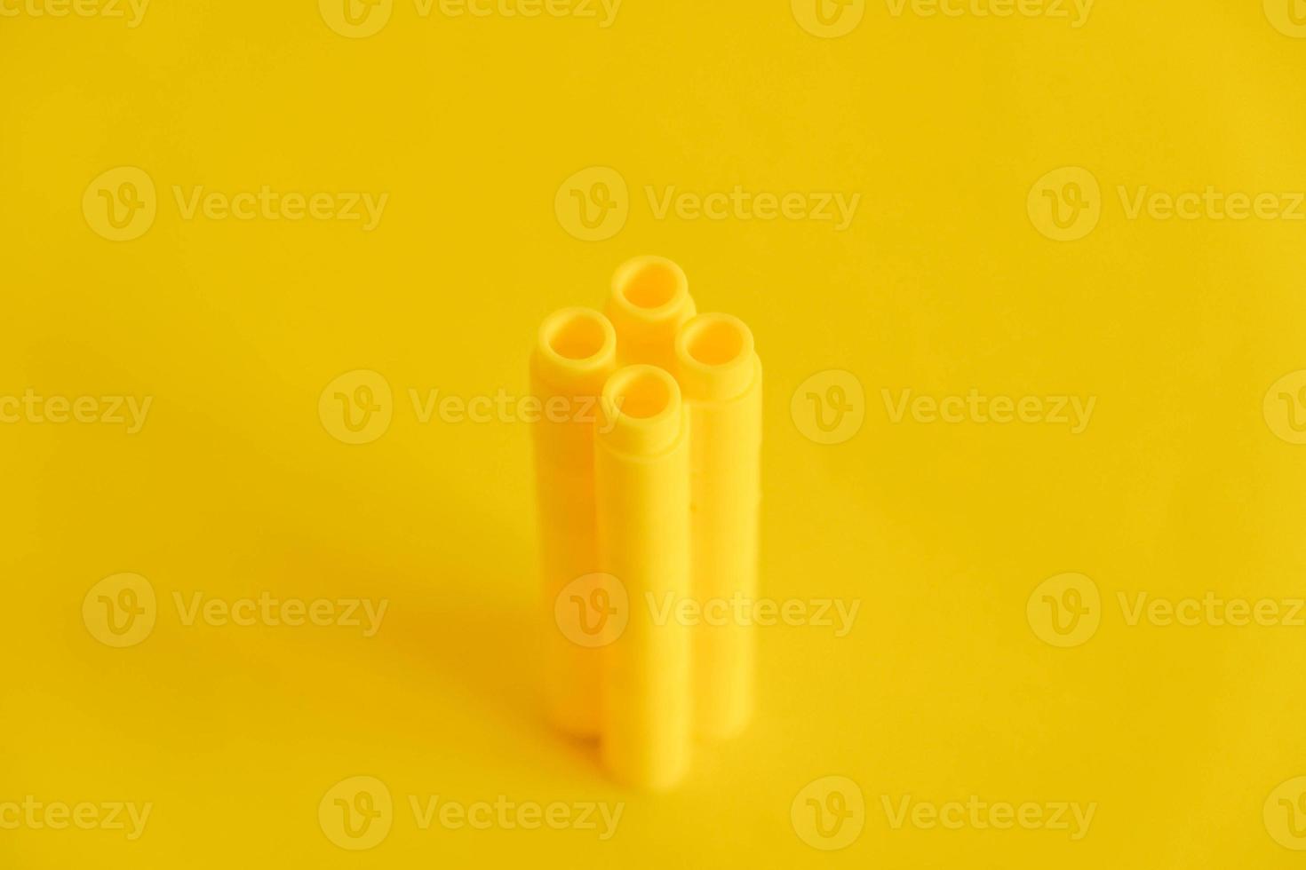 Bloques de construcción de plástico amarillo en forma de torre sobre fondo amarillo foto