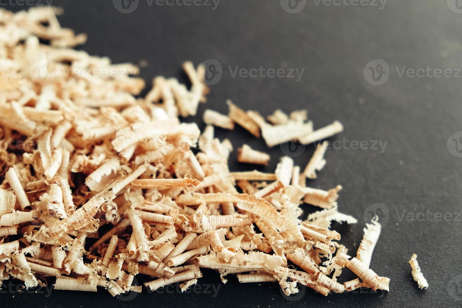 Wood shavings on black background. Background of fresh wood shavings photo