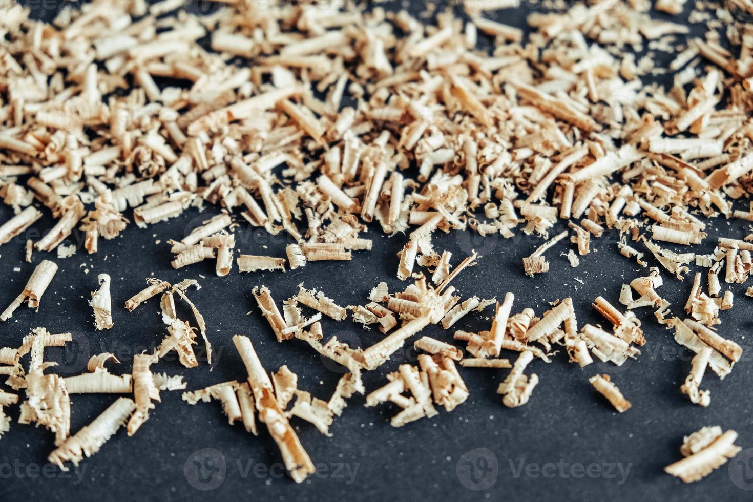 Wood shavings on black background. Background of fresh wood shavings photo