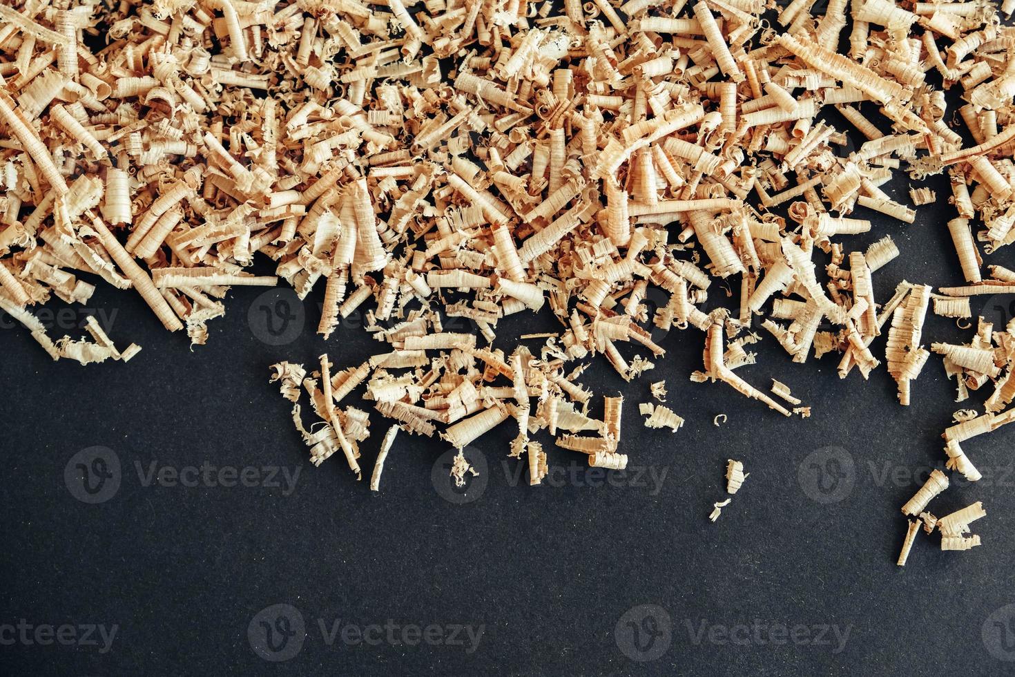 Wood shavings on black background. Background of fresh wood shavings photo