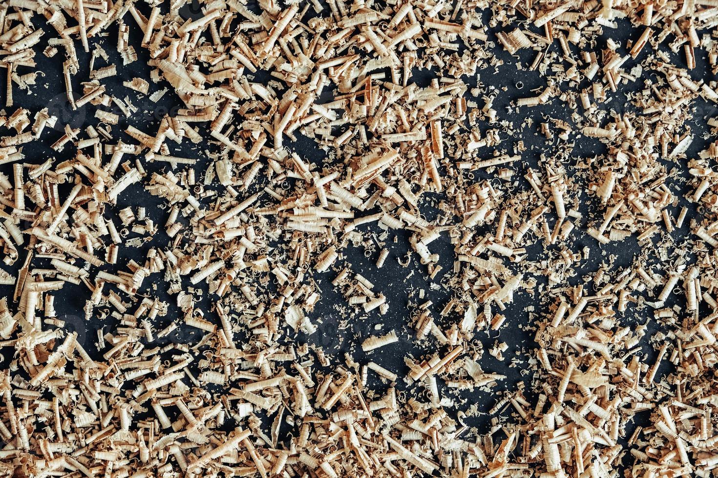 Wood shavings on black background. Background of fresh wood shavings photo