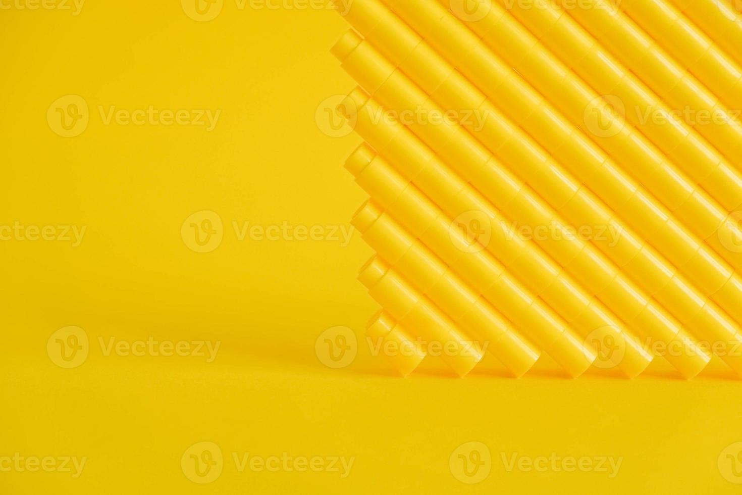 Yellow plastic building blocks in the shape of a pyramid on yellow background photo