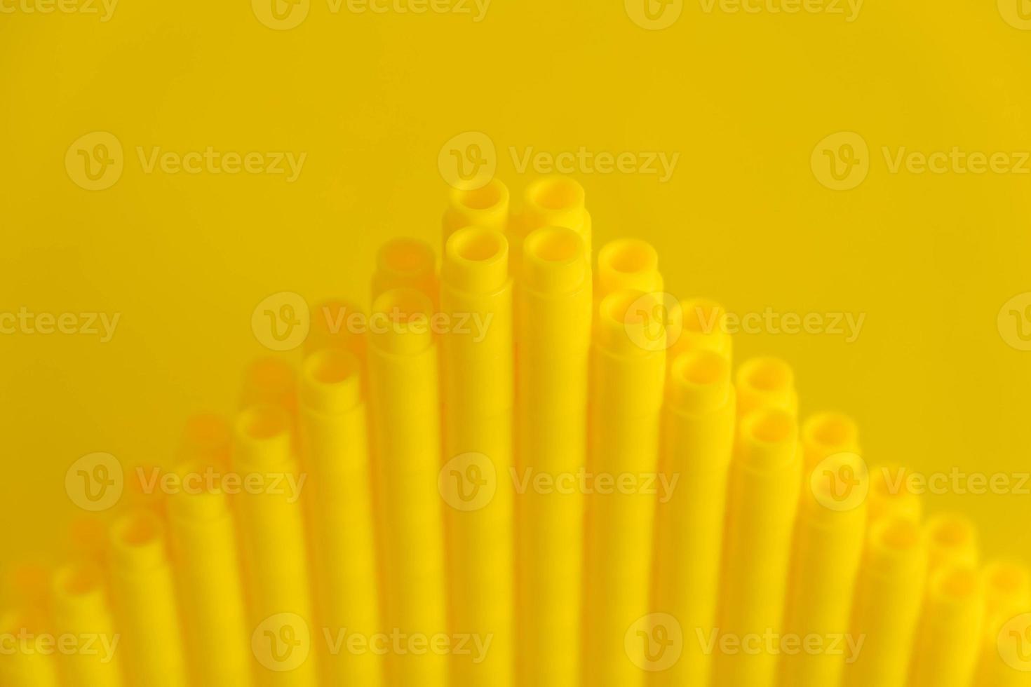 Yellow plastic building blocks in the shape of a pyramid on yellow background photo
