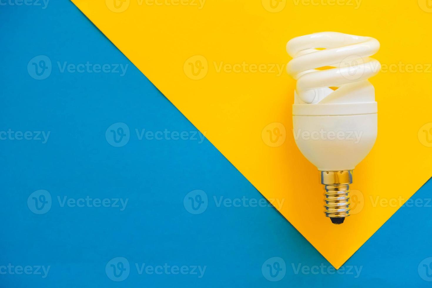 LED light bulb on blue and yellow background photo