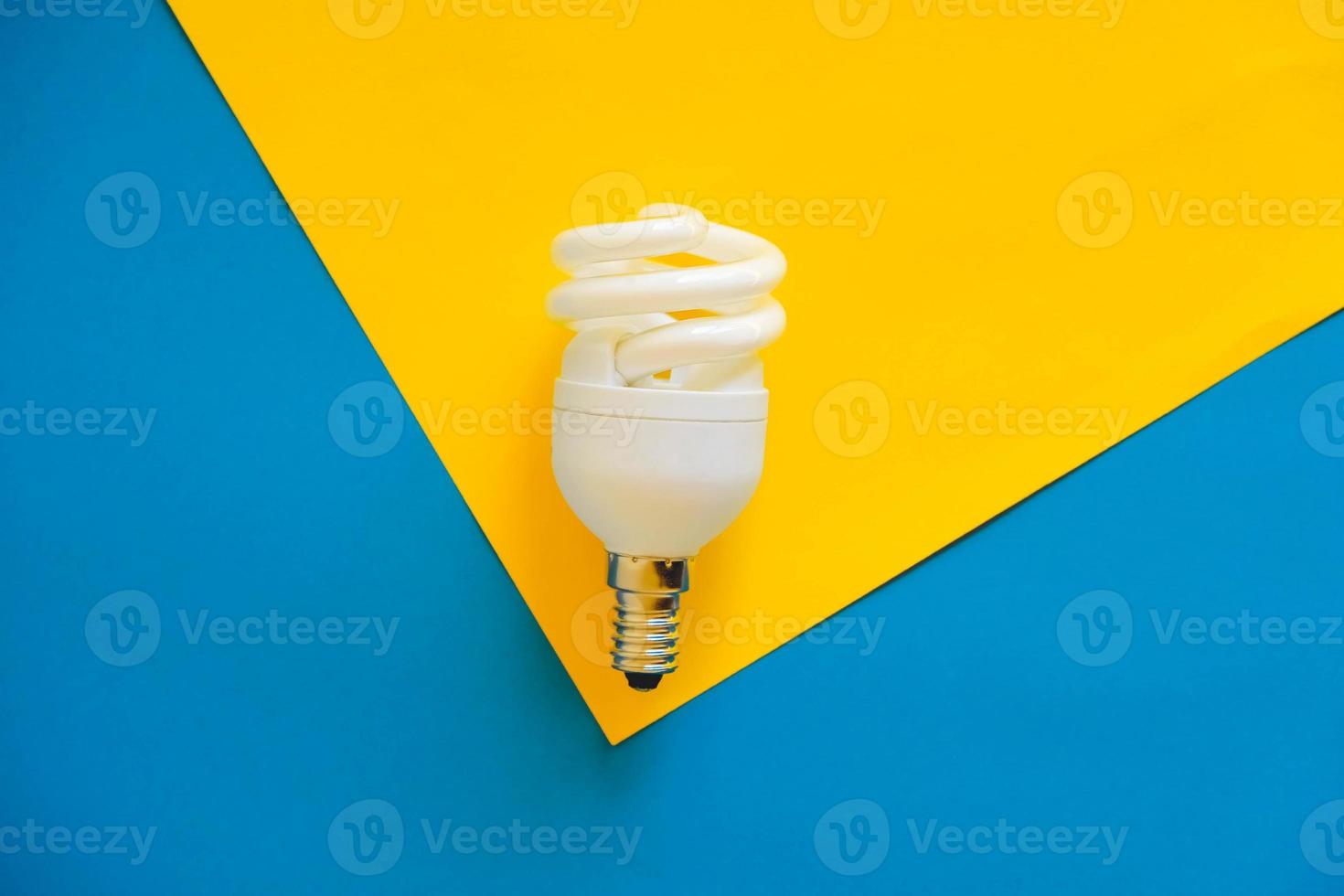 LED light bulb on blue and yellow background photo