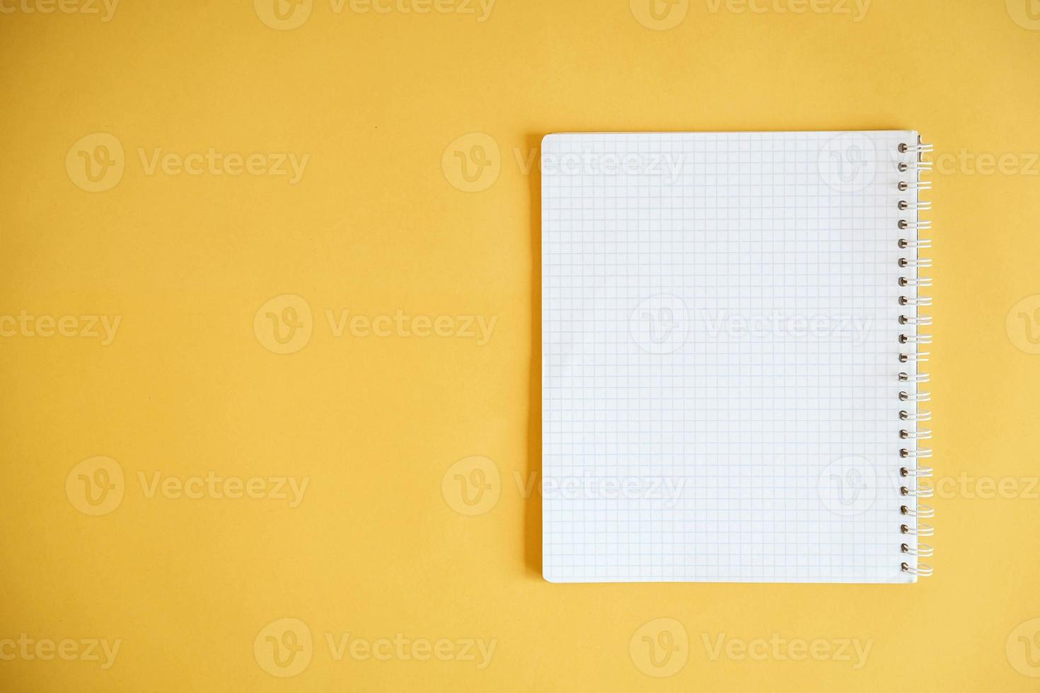 Blank notebook for writing on yellow background photo