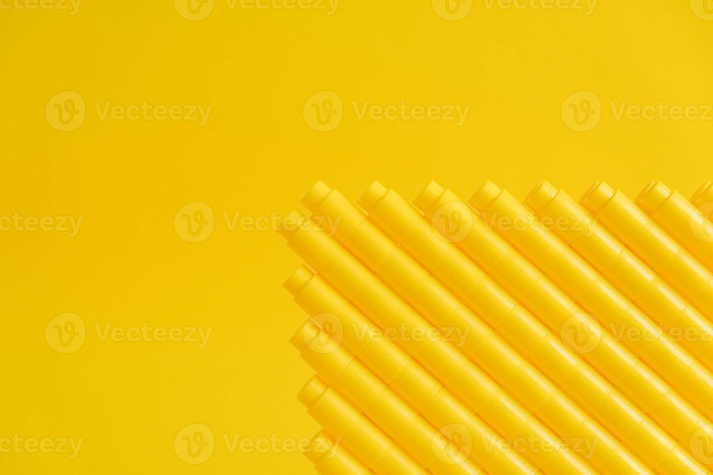 Yellow plastic building blocks in shape of a pyramid on yellow background photo