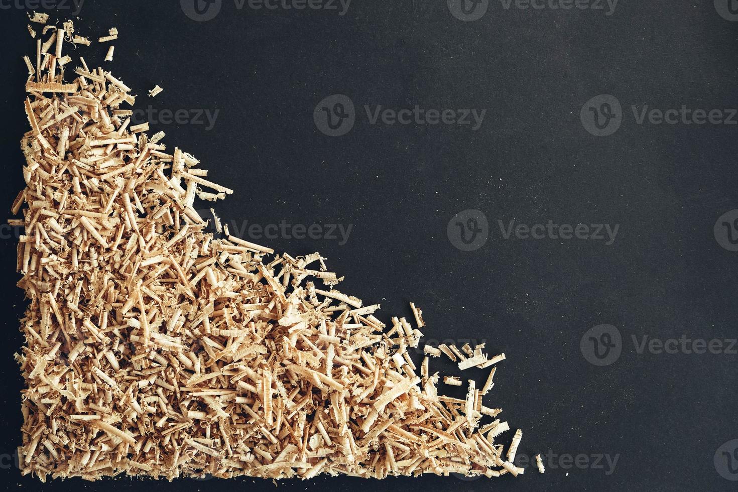 Wood shavings on black background. Background of fresh wood shavings photo