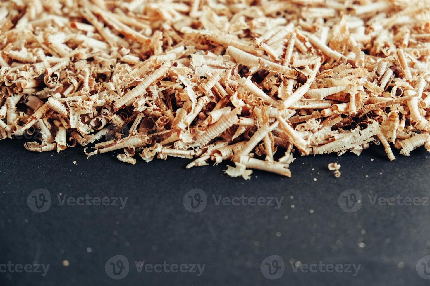 Wood shavings on black background. Background of fresh wood shavings. Copy, empty space for text photo