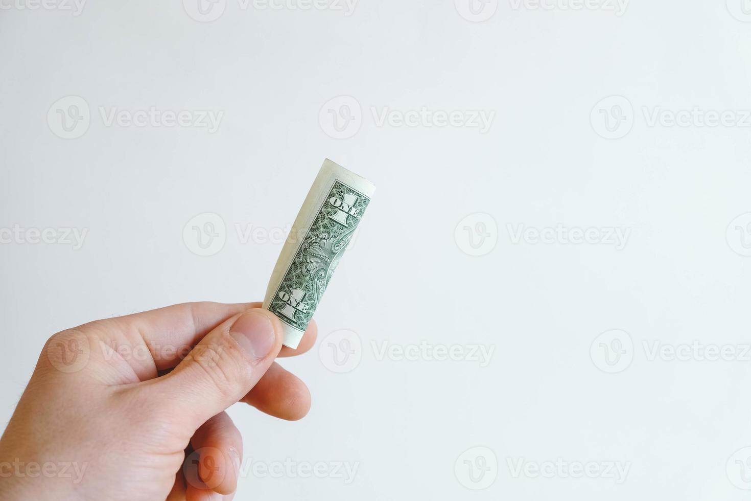 un dólar en la mano sobre un fondo blanco foto