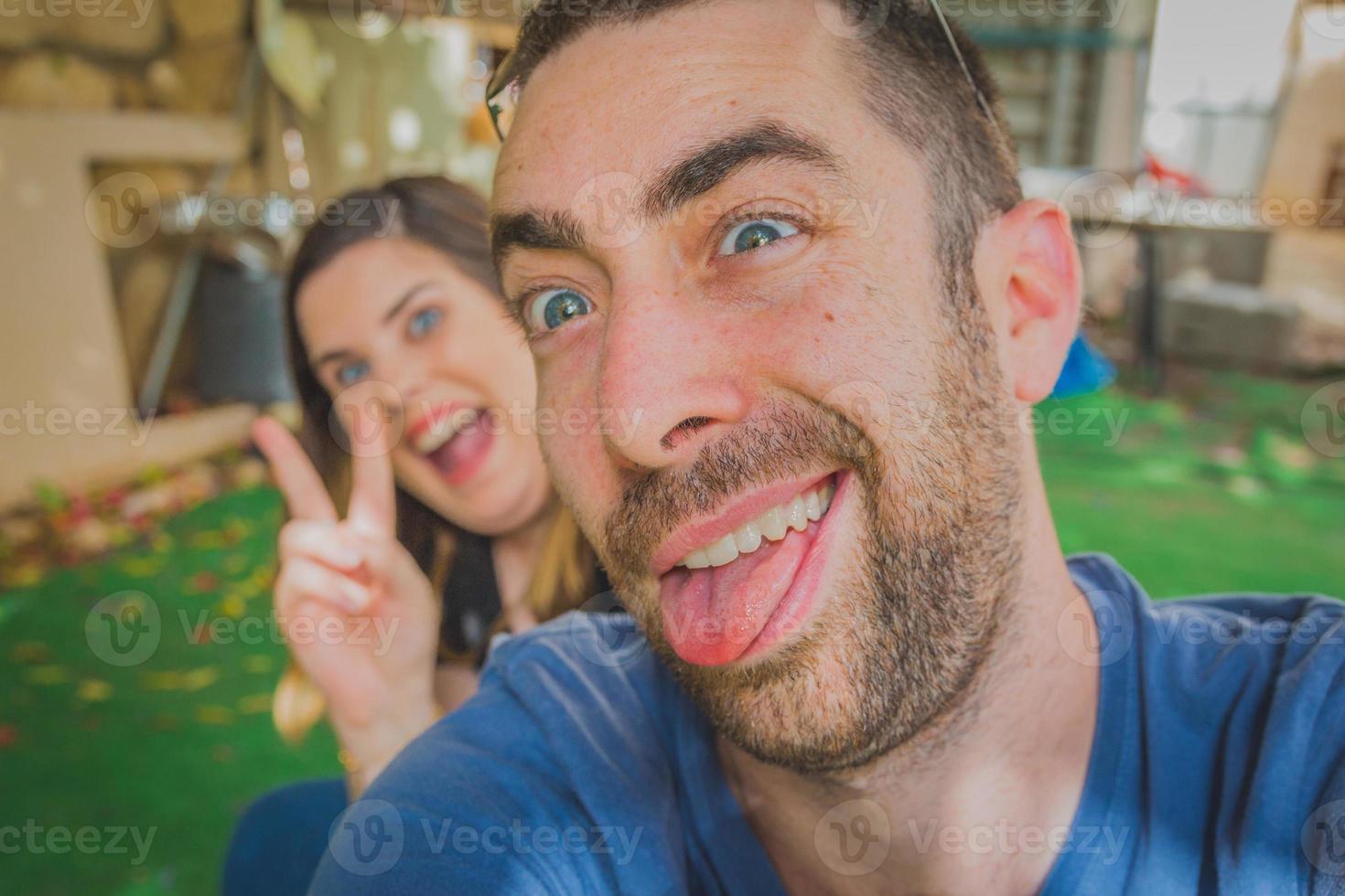 Young couple enjoying together in the backyard. They are smiling, laughing and making funny faces together photo