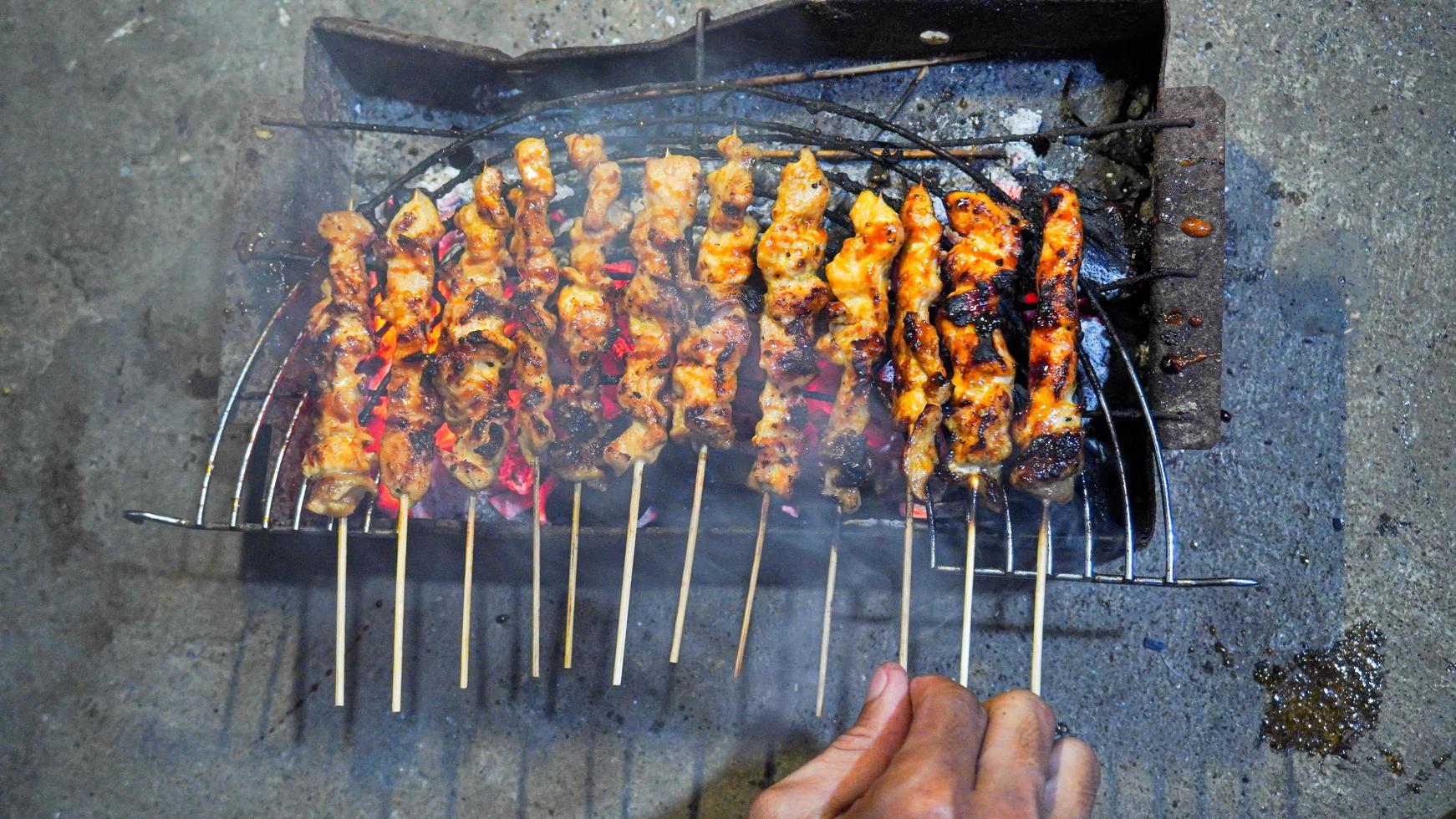 the process of making satay food, grilled over charcoal coals photo