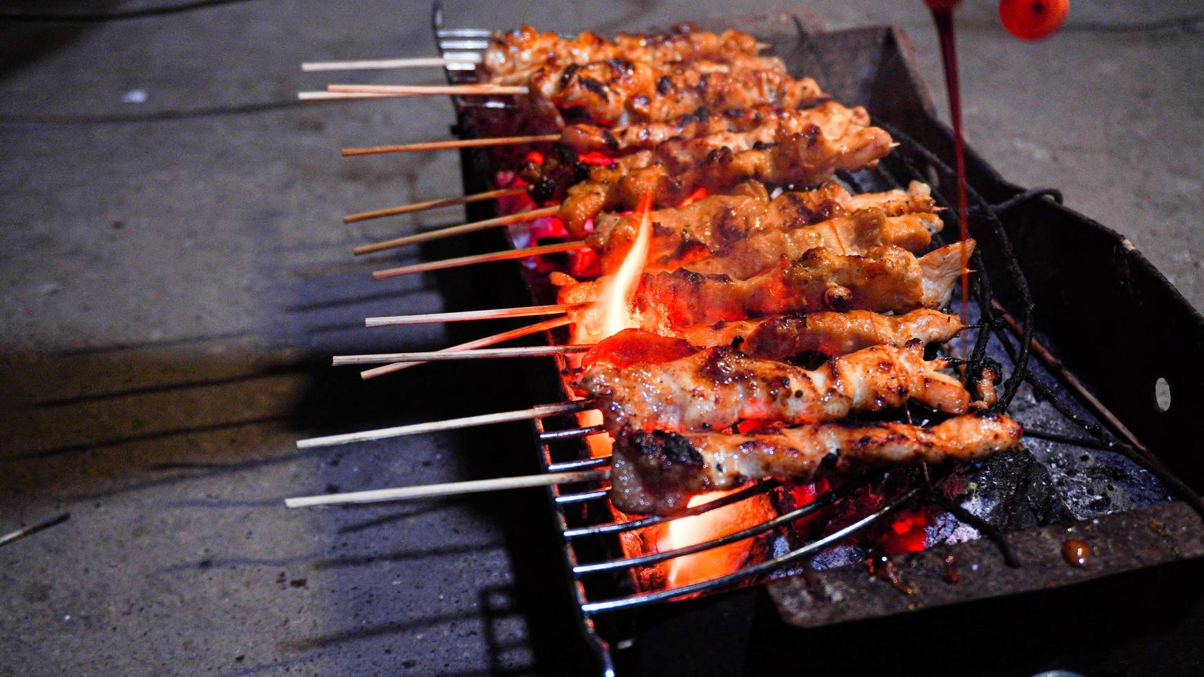 el proceso de hacer comida satay, asada sobre brasas de carbón foto