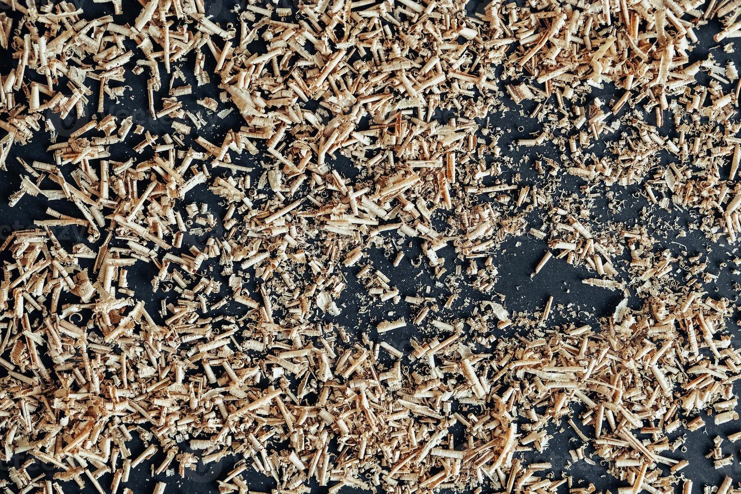 Wood shavings on black background. Background of fresh wood shavings photo