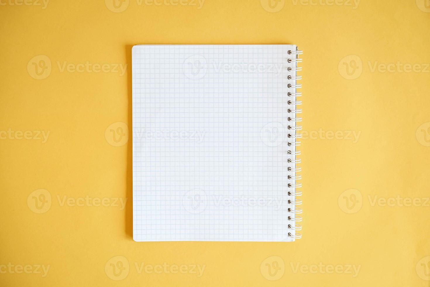 Blank notebook for writing on yellow background photo