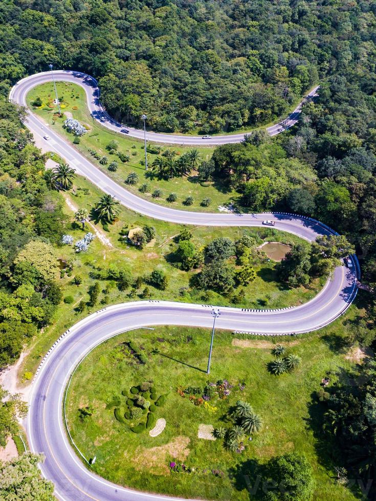 Vista aérea de los coches que atraviesan una carretera curva en la montaña. foto