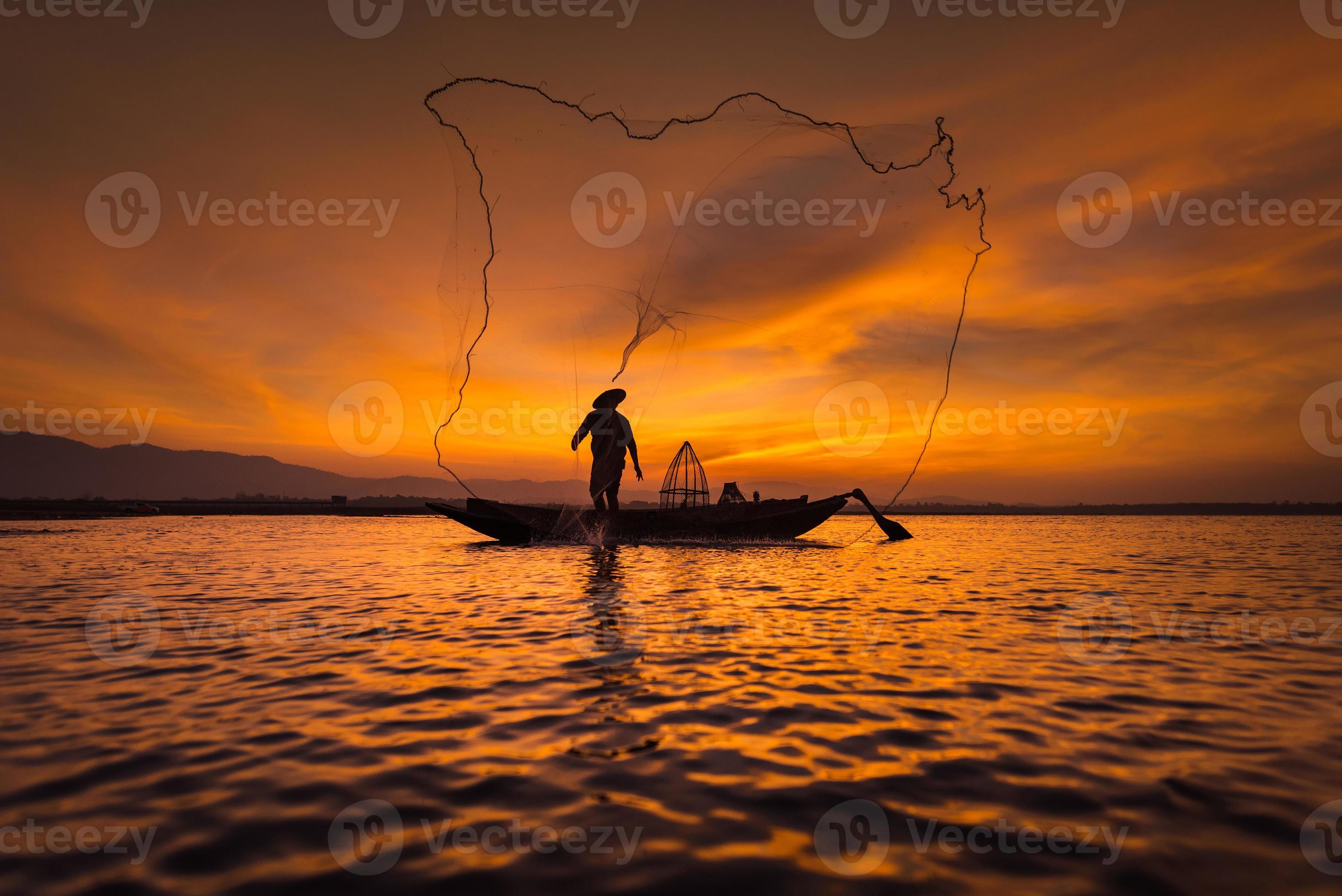 Asian fisherman on wooden boat casting a net for catching