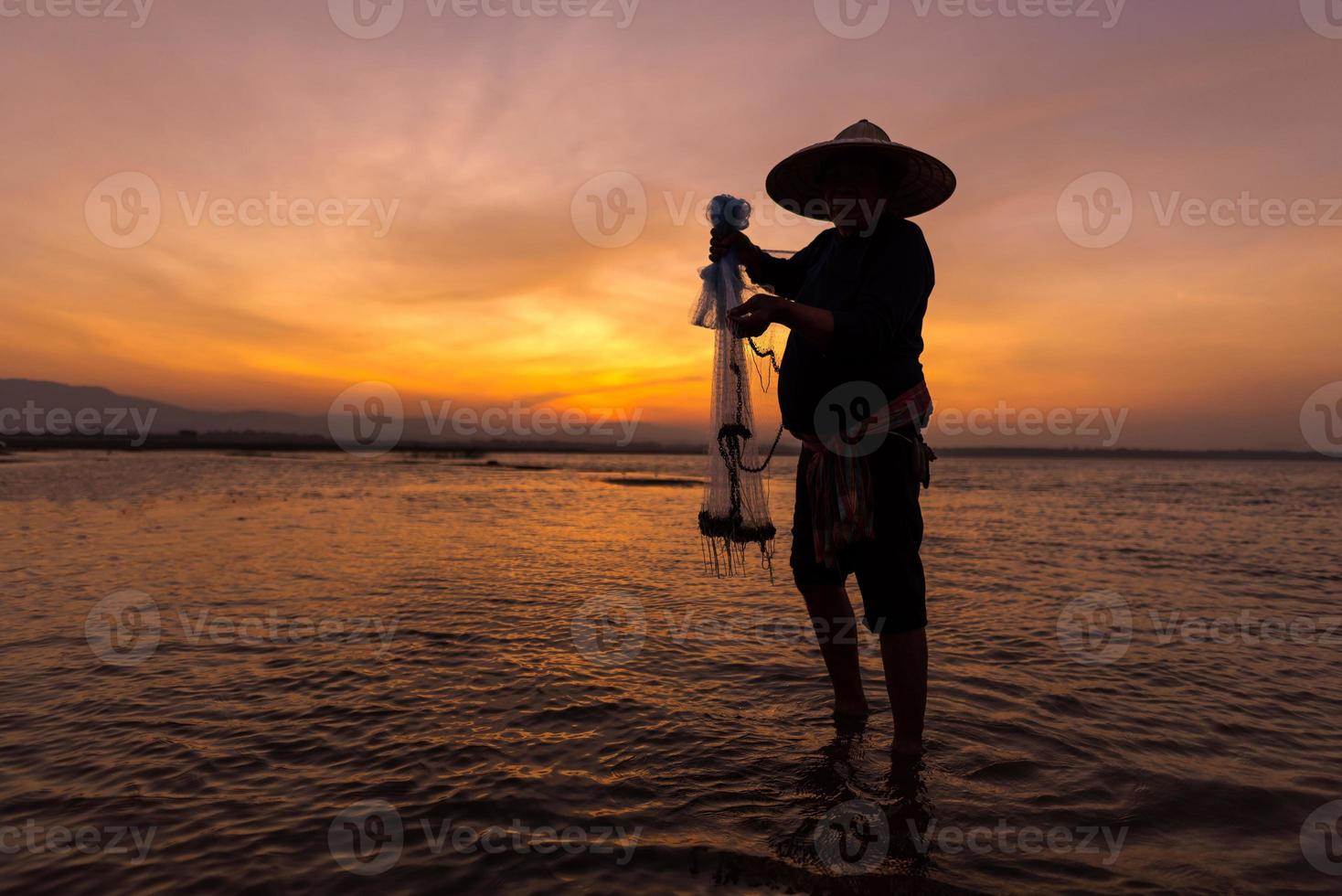 Asian fisherman in nature river at the early morning before sunrise photo