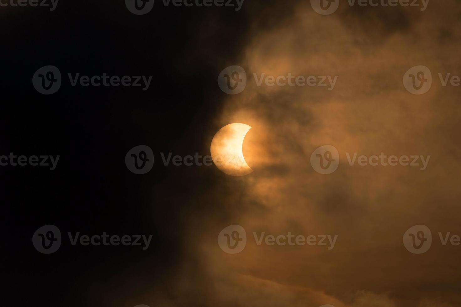 la luna cubriendo el sol en un eclipse parcial con nubes dramáticas. antecedentes científicos, fenómeno astronómico foto