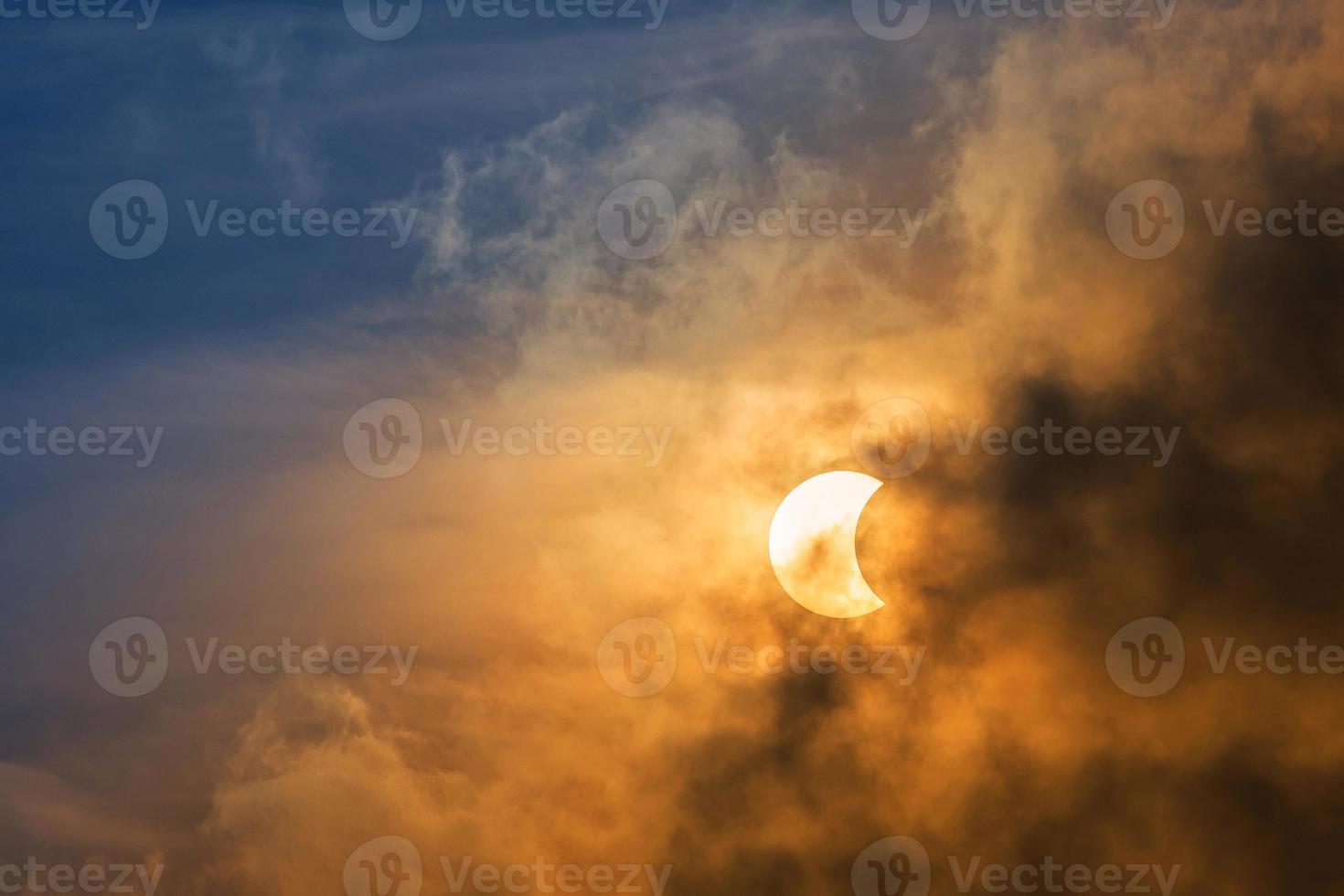 la luna cubriendo el sol en un eclipse parcial con nubes dramáticas. antecedentes científicos, fenómeno astronómico antecedentes de la naturaleza. foto