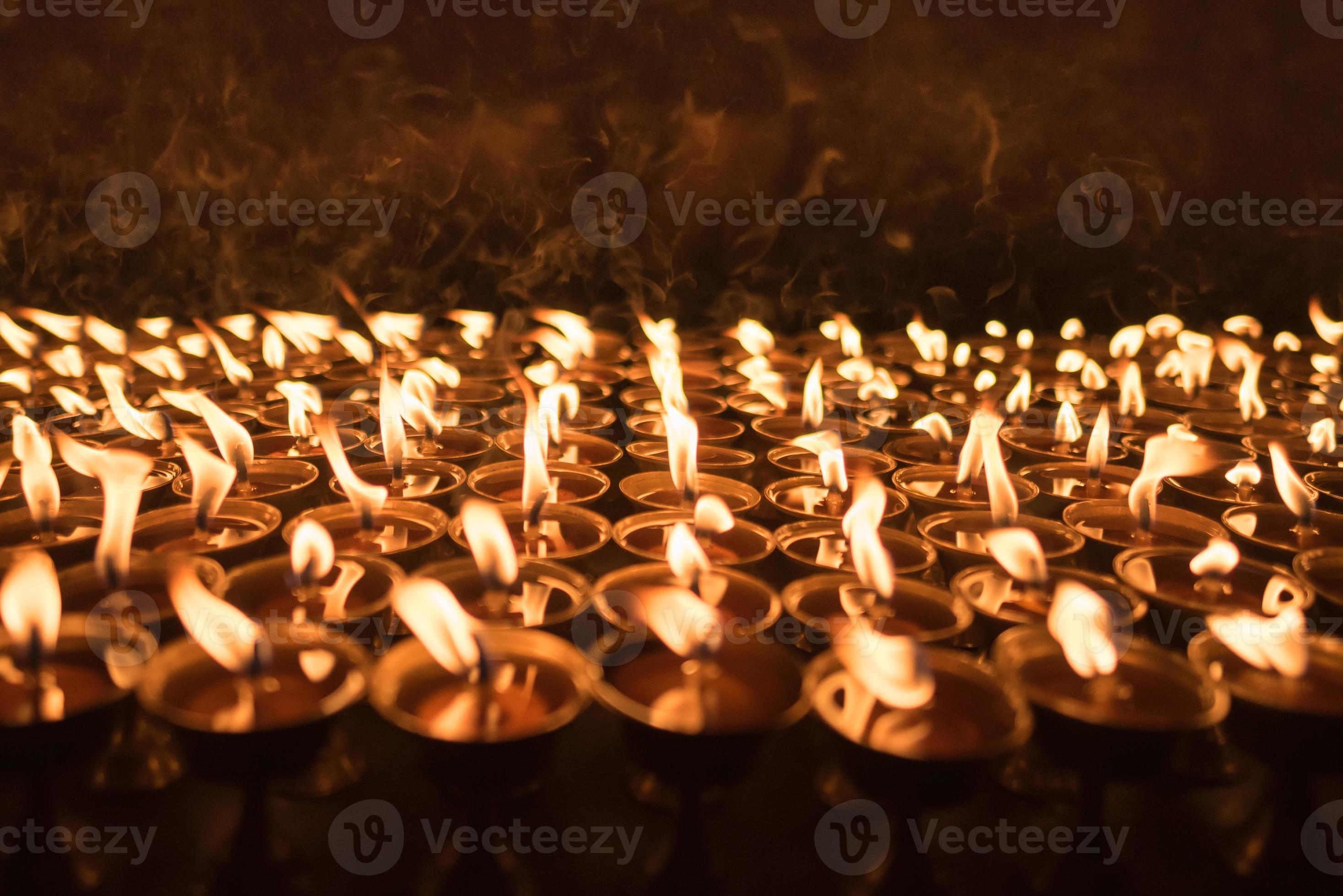 A ground of burning candles lighting up at buddhist temple in Kathmandu