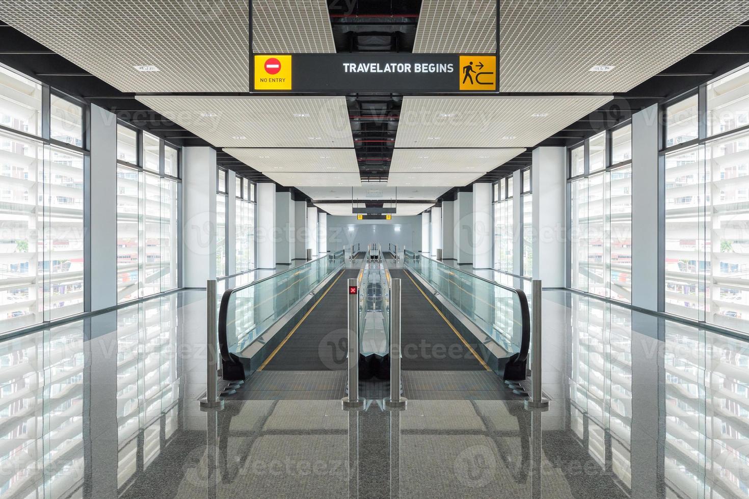 La pasarela moderna de la escalera mecánica avanza y la escalera mecánica se mueve hacia atrás en el aeropuerto internacional. La escalera mecánica es una instalación para el transporte de apoyo en un edificio moderno. foto