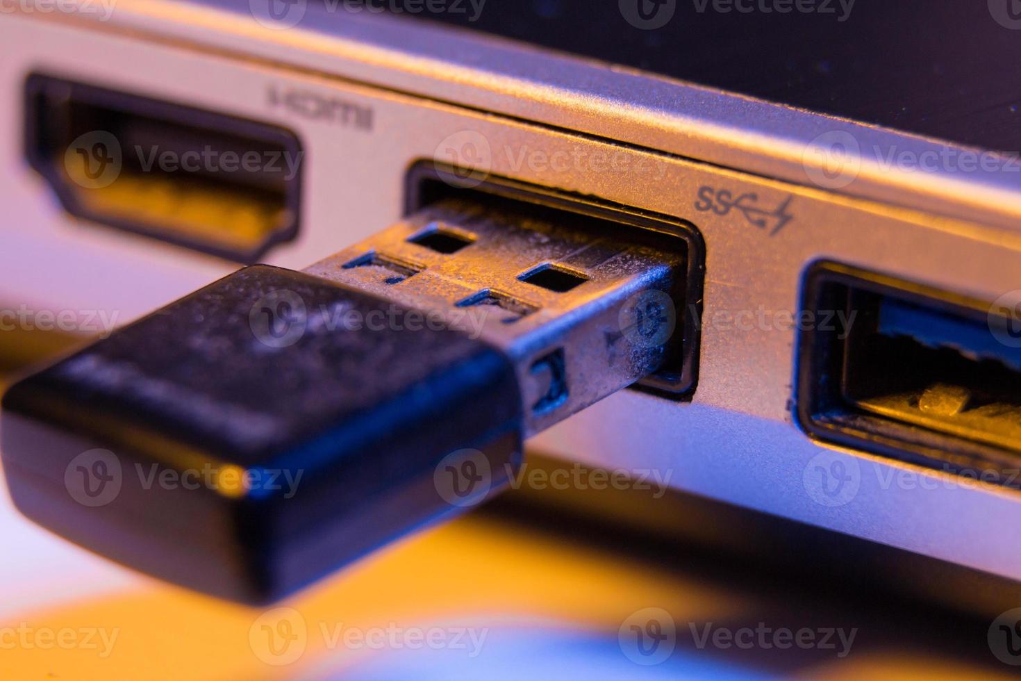 Closeup of USB flash drive inserted into port on the side of a laptop photo