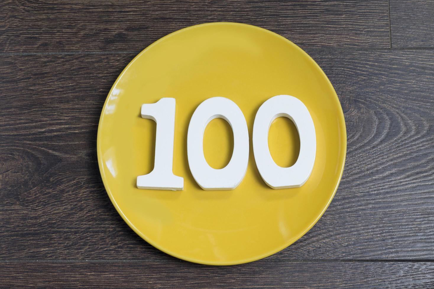 The number one hundred on the yellow plate. photo