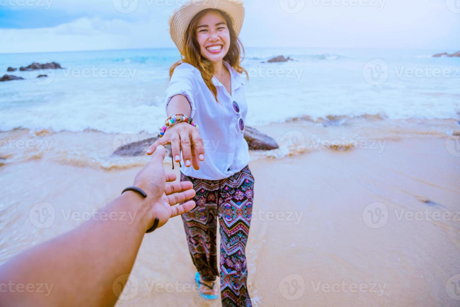 Asian lovers happy travel nature on the beach. Couple running on a sandy beach.Travel relax in summer photo