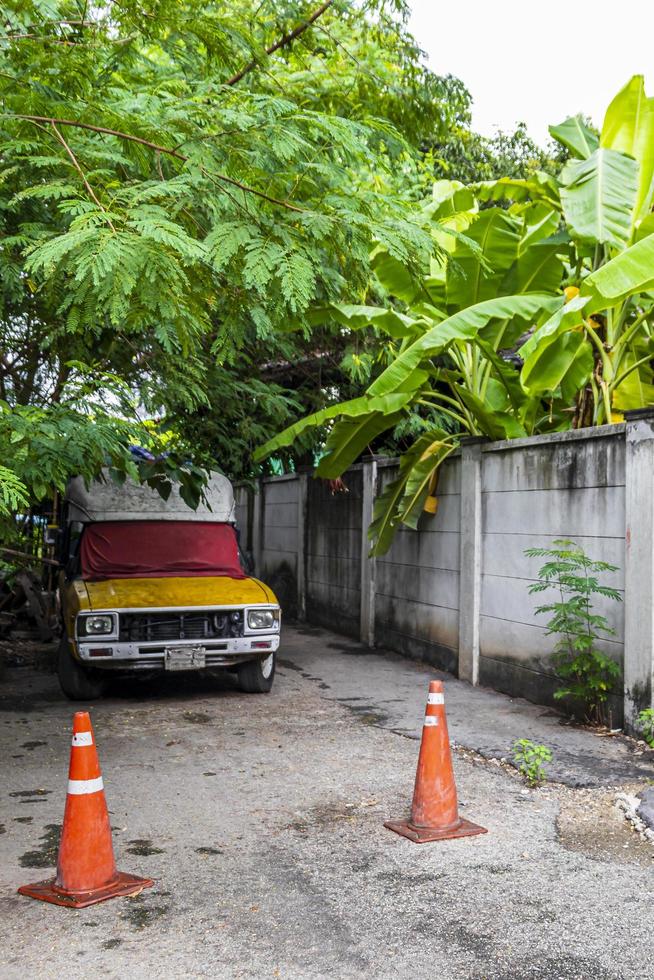 Coche viejo abandonado en el bosque tropical en Bangkok, Tailandia. foto