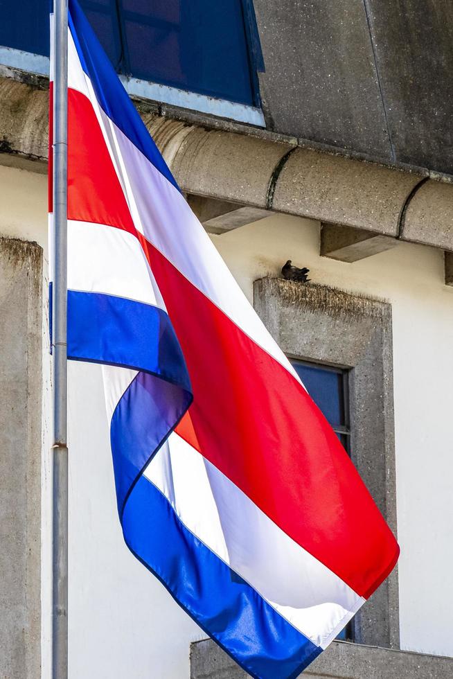 Flag of Costa Rica old buildings behind Costa Rican flag. photo