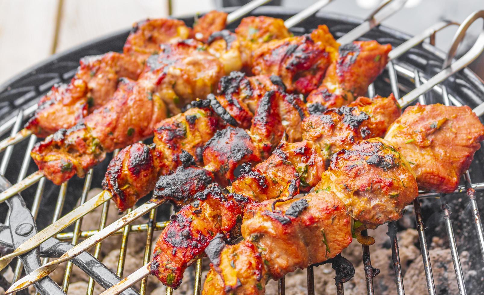 Russian shashlik with skewers on a round grill. photo