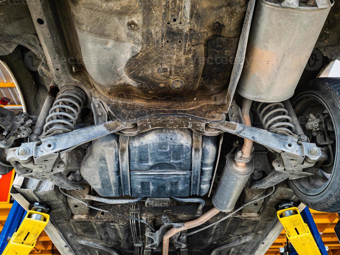 Lifting car engine and suspension system awaiting maintenance in garage photo