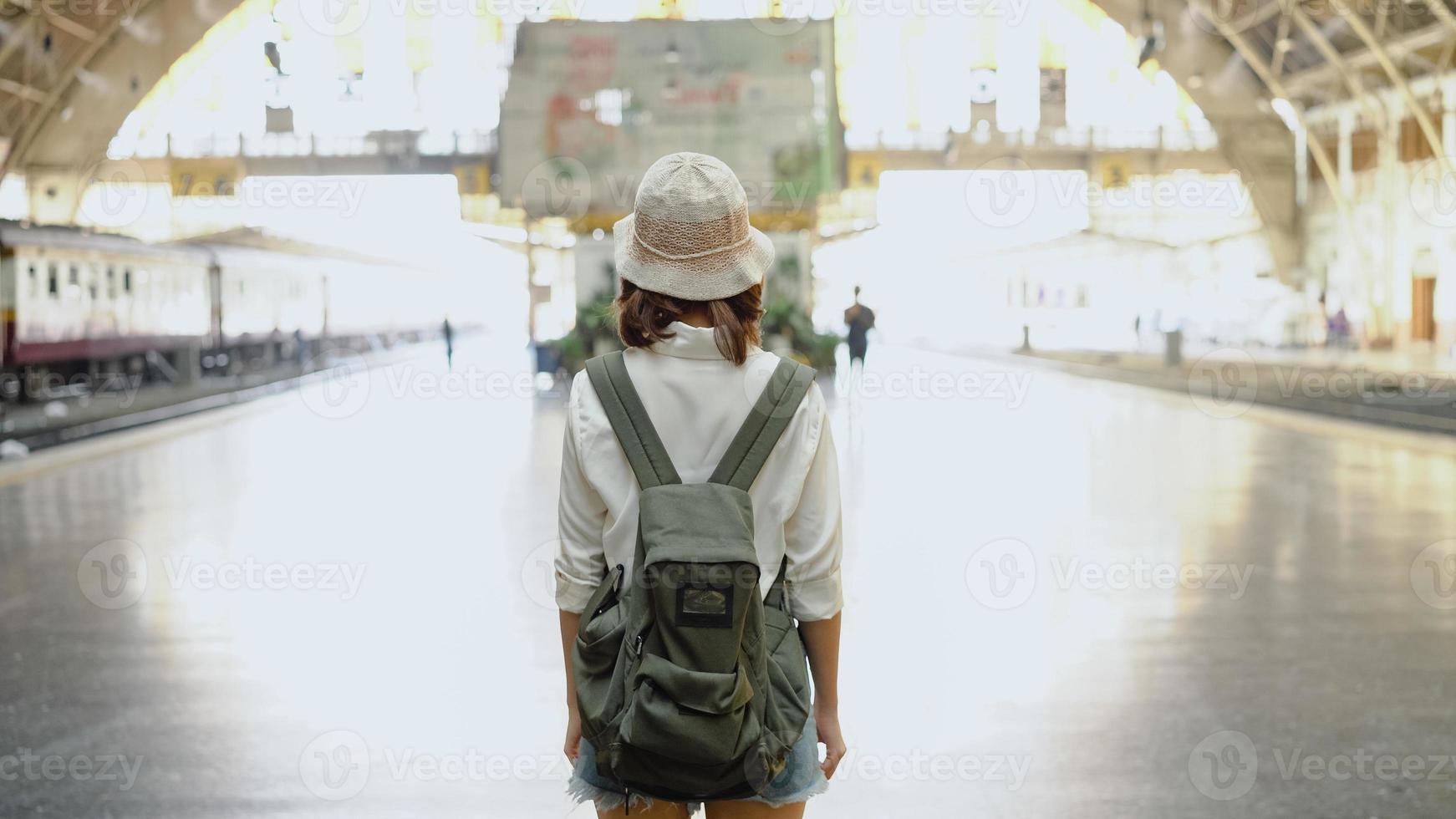 viajero, mochilero, mujer asiática, viaje, en, bangkok, tailandia. feliz dirección femenina joven y mirando en el mapa de ubicación en la estación de tren antes de viajar. foto