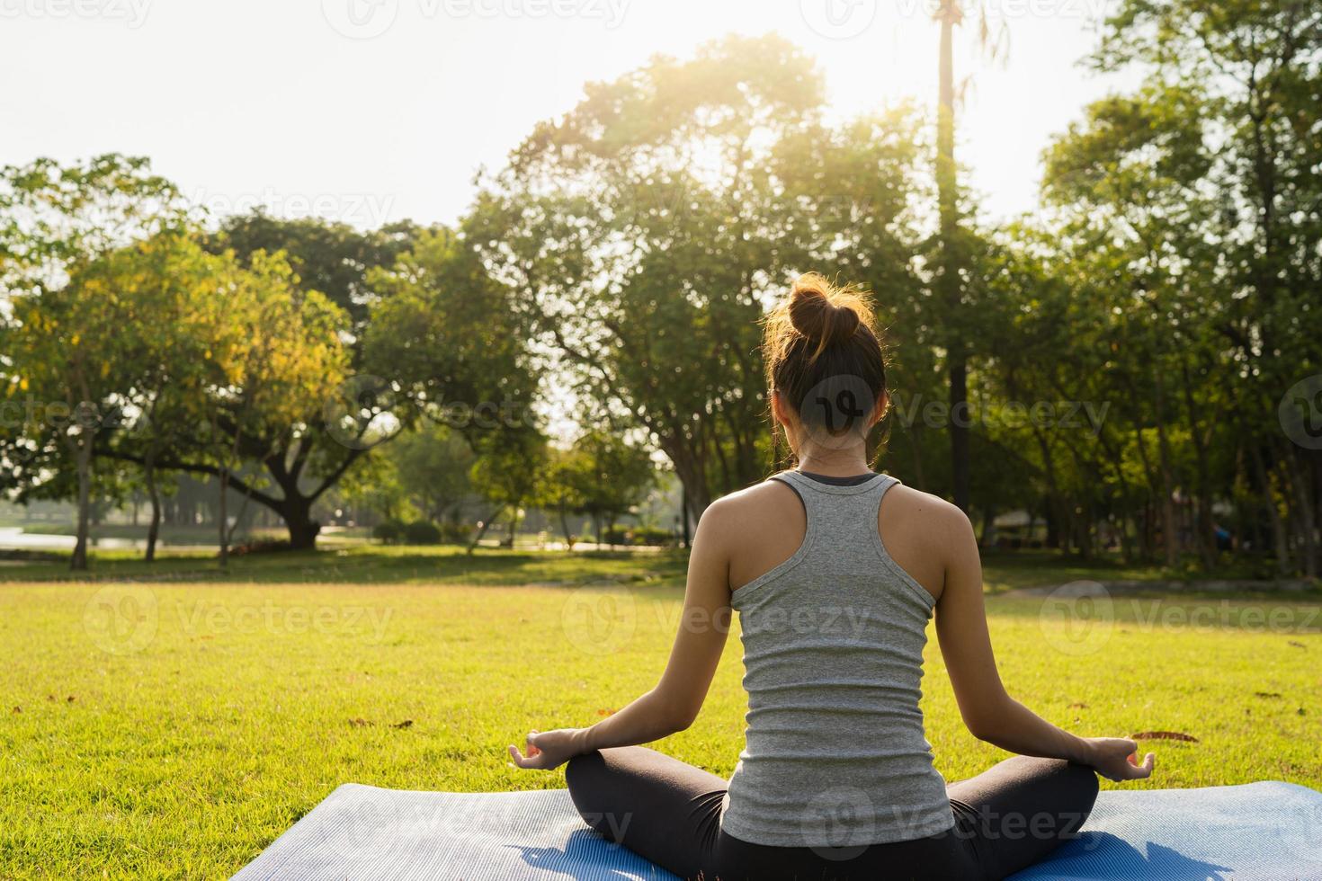 joven mujer asiática yoga al aire libre mantenga la calma y medite mientras practica yoga para explorar la paz interior. el yoga y la meditación tienen buenos beneficios para la salud. deporte de yoga y concepto de estilo de vida saludable. foto