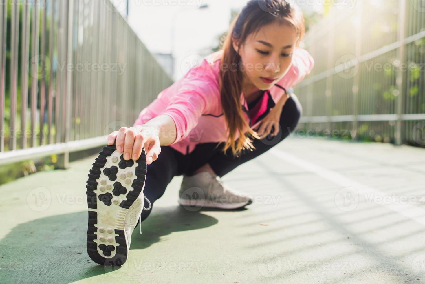 Fitness sport girl fashion sportswear doing yoga fitness exercise in street. Fit young asian woman doing training workout in morning. Young happy asian woman stretching at park after running workout. photo