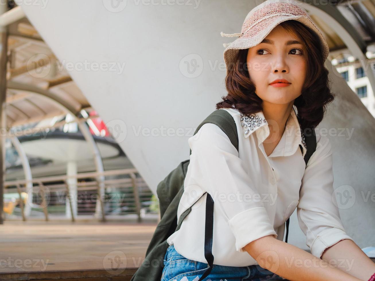 Attractive young smiling Asian woman outdoors portrait in the city real people series. Outdoors lifestyle fashion portrait of happy smiling Asian girl. Summer outdoor happiness portrait concept. photo