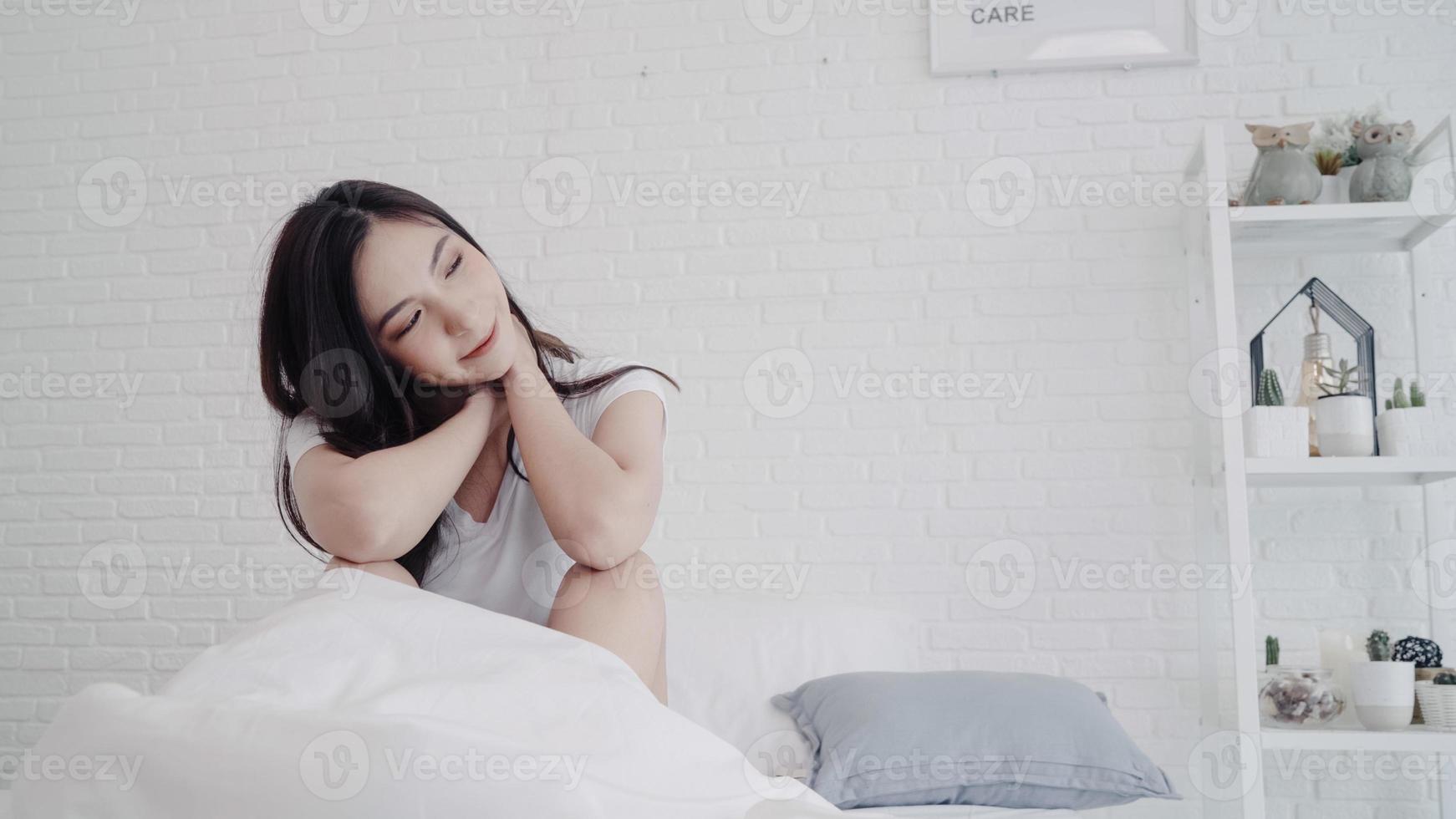 Beautiful Asian woman stretching her body after she wake up in her bedroom at home. Happy female enjoy sunny morning. Lifestyle woman at home concept. photo