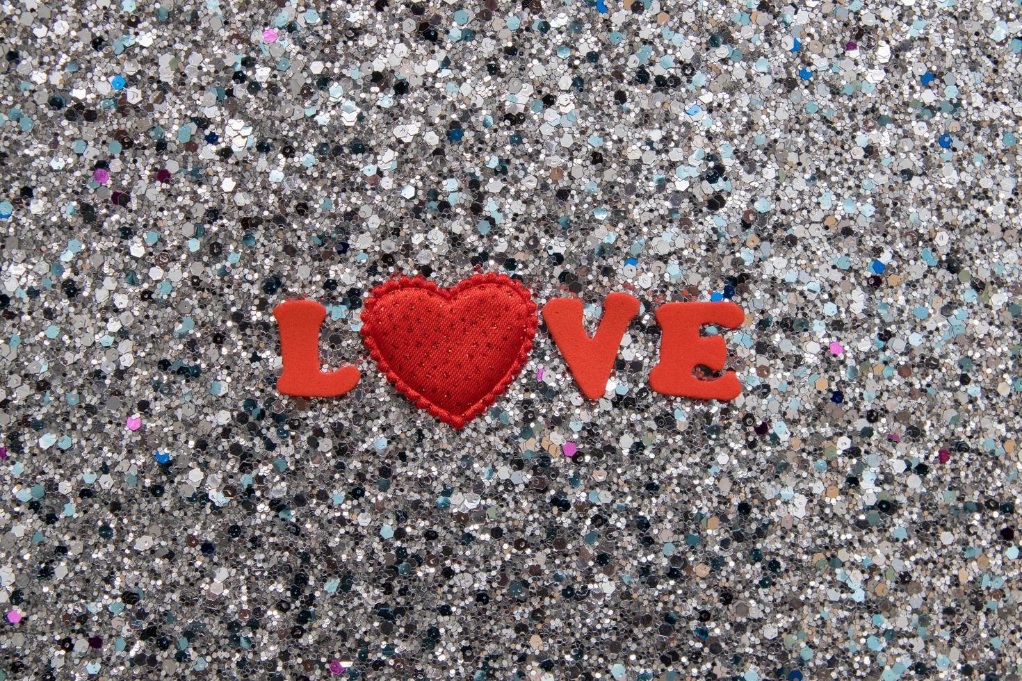 The word Love in red letters and a heart on a shiny glitter background for Valentine's Day photo