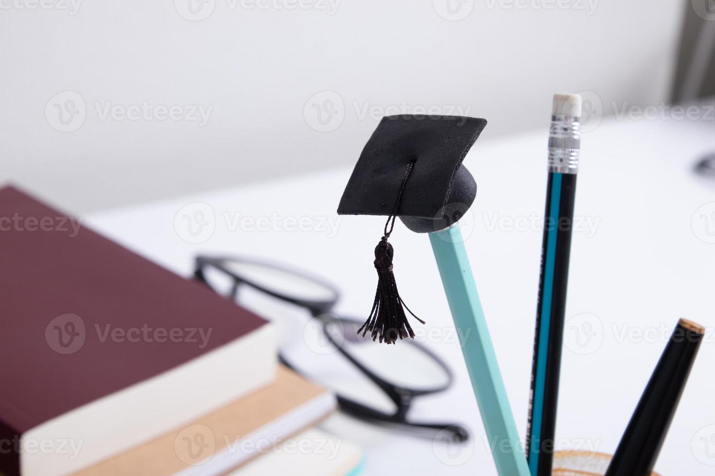 una gorra de un lápiz en el fondo de un escritorio con material de oficina. concepto de aprendizaje en línea en el hogar foto