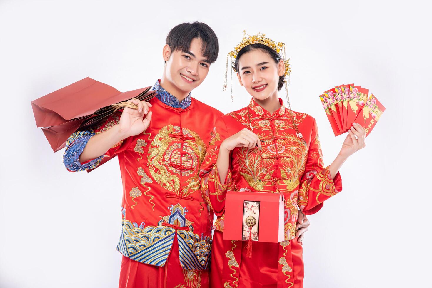 The Man and woman wear cheongsam get the red bag , gift money and some gift from their relative in traditional day photo